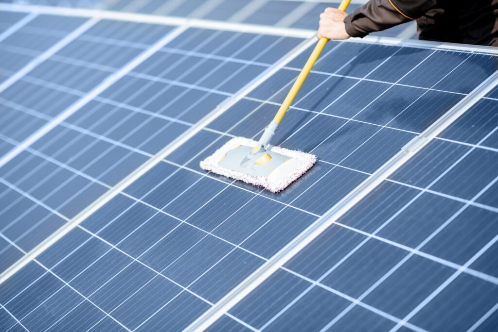 Workman cleaning solar panels